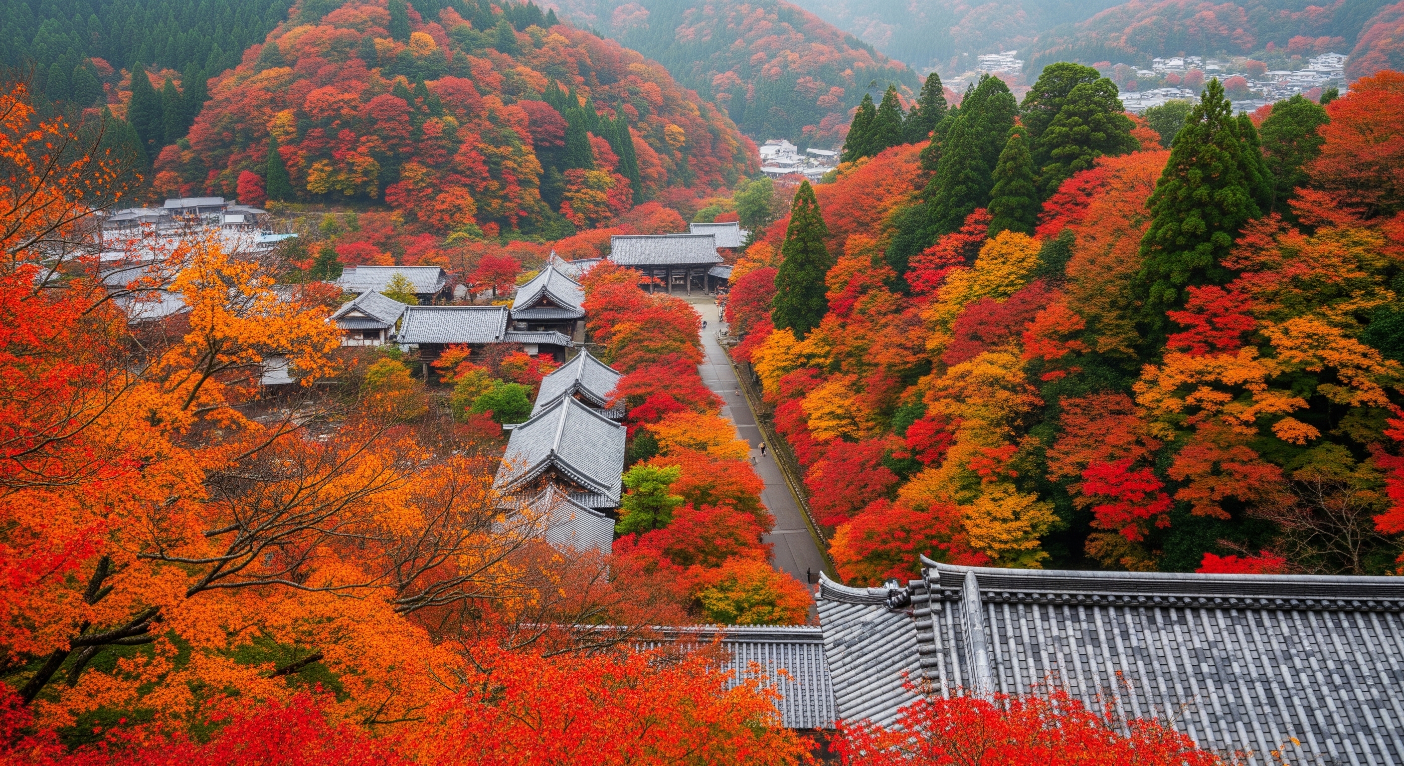 Tsutenkyo bridge at Tofukuji temple viewed from above, looking down into a sea of vivid scarlet and orange Japanese maple trees filling the valley below