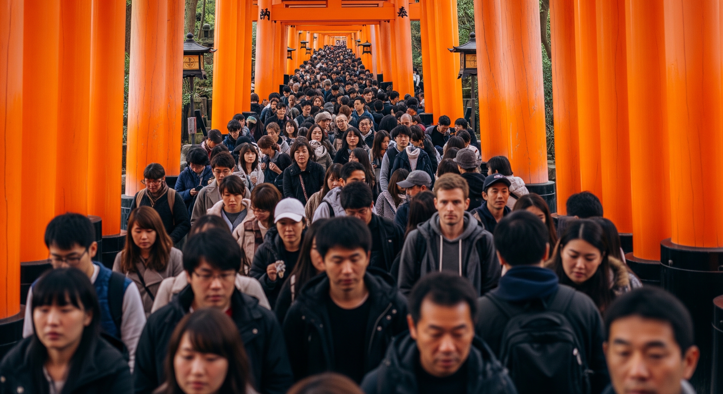 Dense crowds walking through Fushimi Inari torii gates at midday