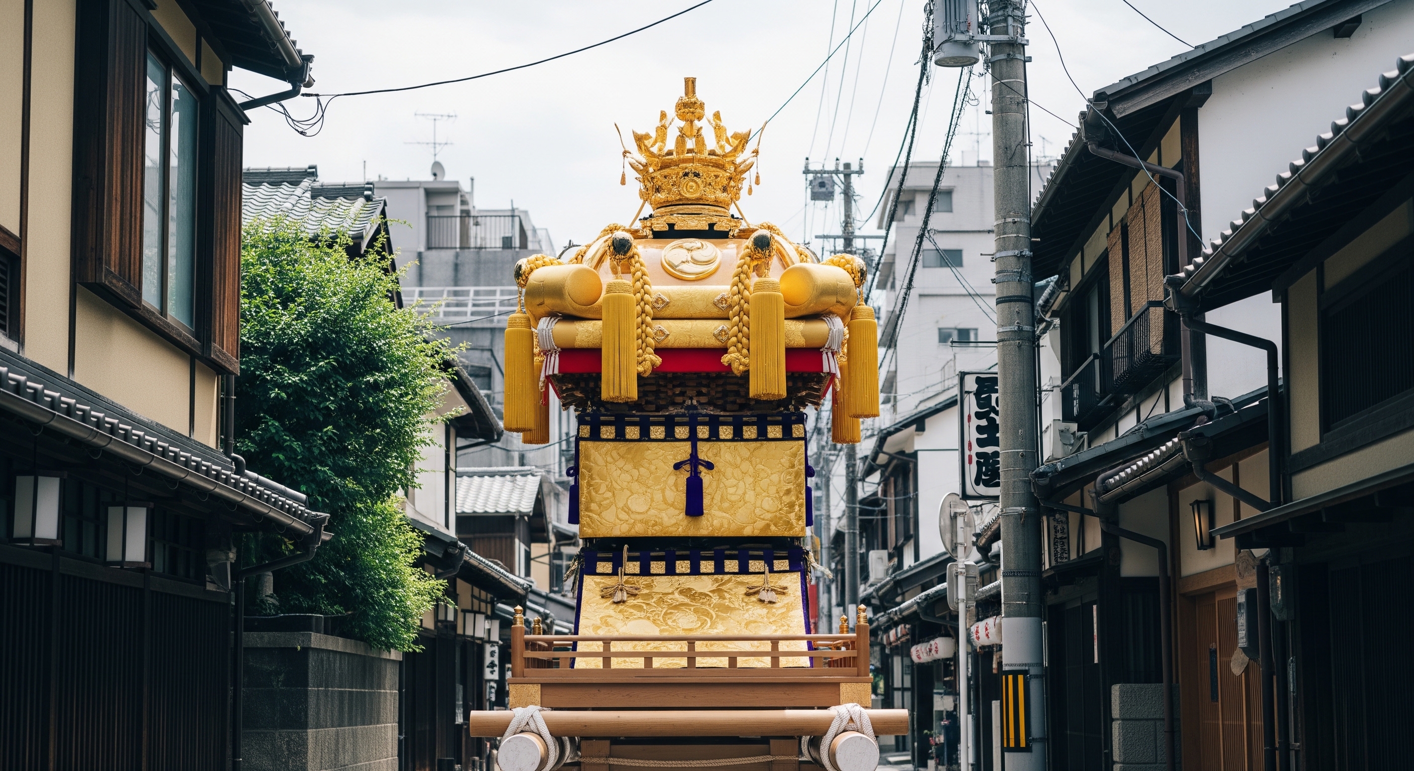 Towering Yamaboko float decorated with golden tapestries on the streets of central Kyoto