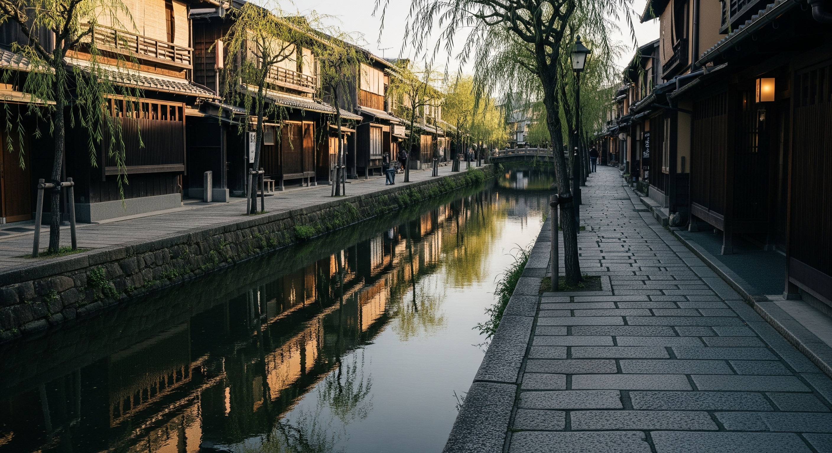 Shimbashi canal in Gion district with traditional ochaya teahouses reflected in still water, willow trees and stone lanterns lining the bank